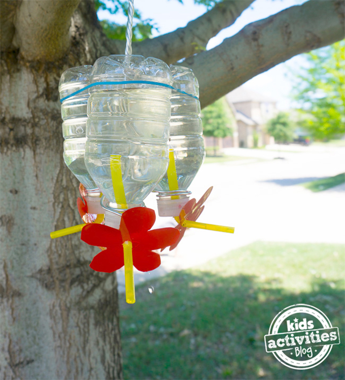 Upside down water bottle with water and sugar, straws an flowers- kids activities blog