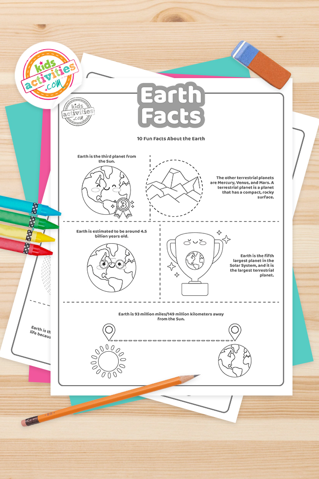 Printed PDF files of fun earth facts stacked on wooden table surrounded by pencil and crayons - Kids Activities Blog
