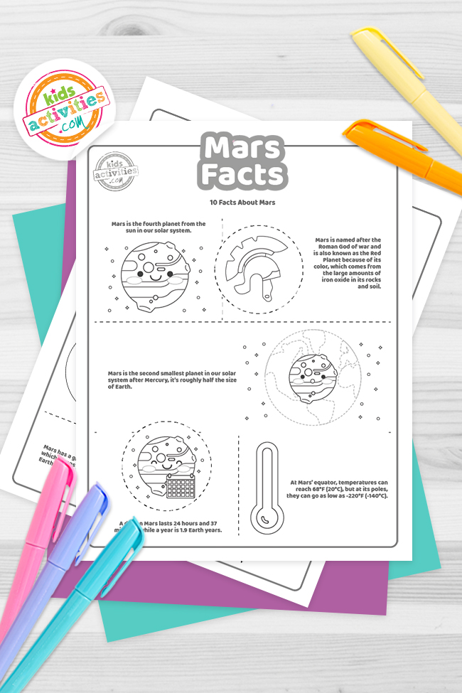 Printed PDF files of fun Mars facts stacked on a wooden table surrounded by pencil and crayons - Kids Activities Blog