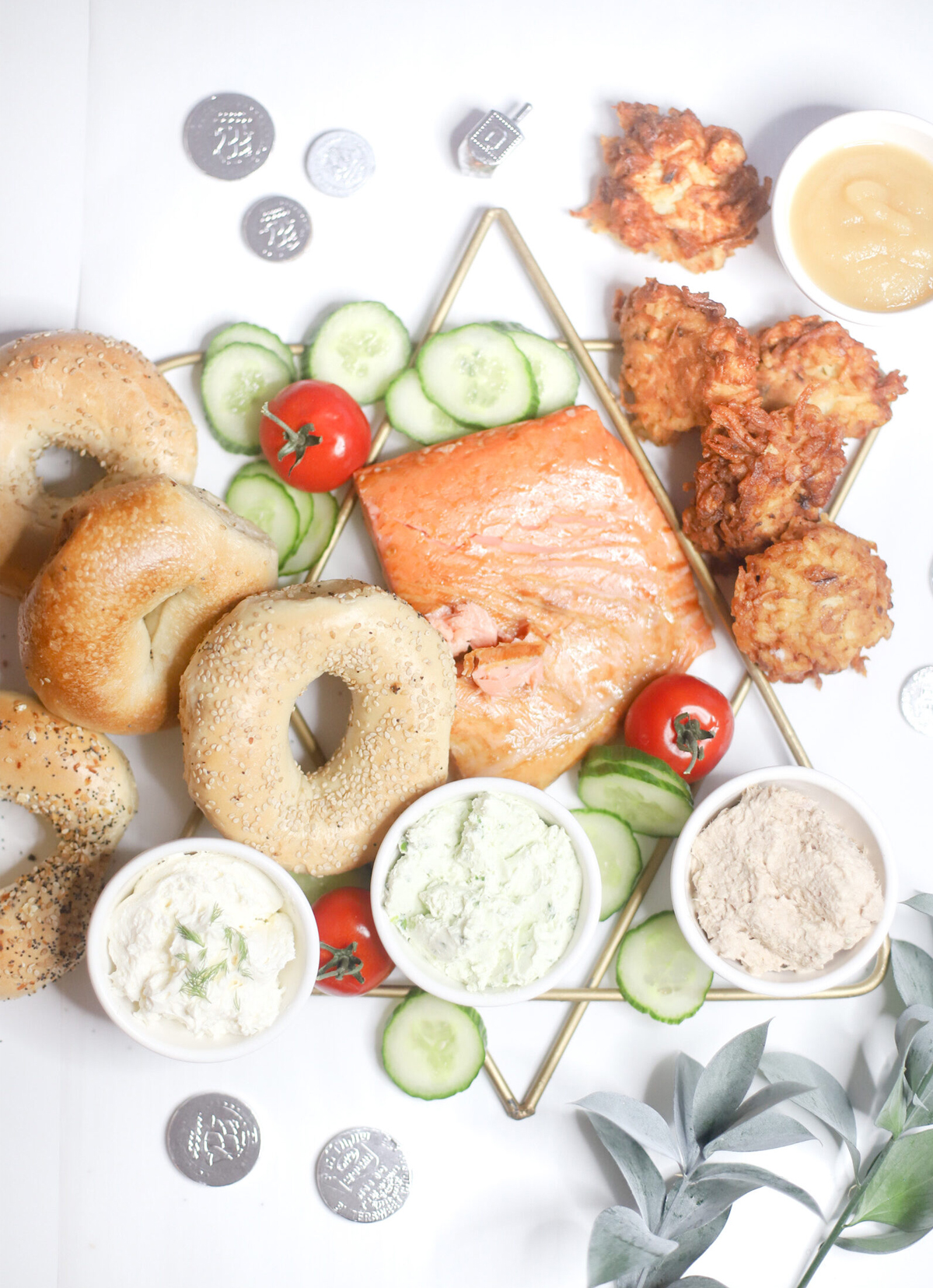 pan seared salmon, bagels, latkes, and dips make up this board from glitter inc.