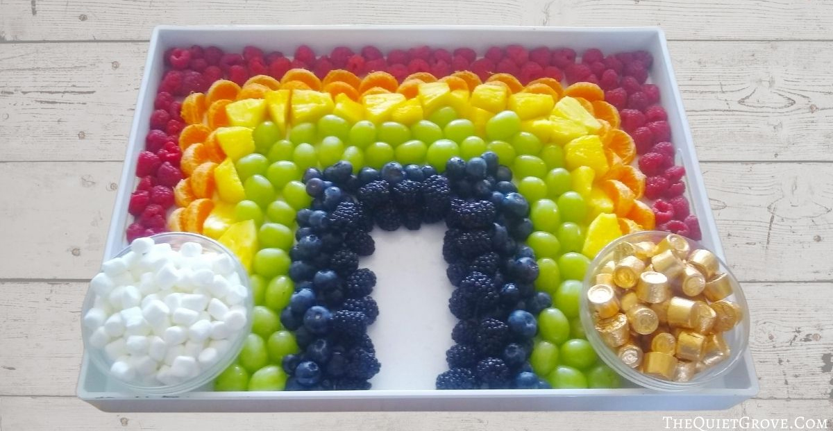 the quiet grove has a rainbow on a square dish with marshmallows and rolos with colorful fruit. 