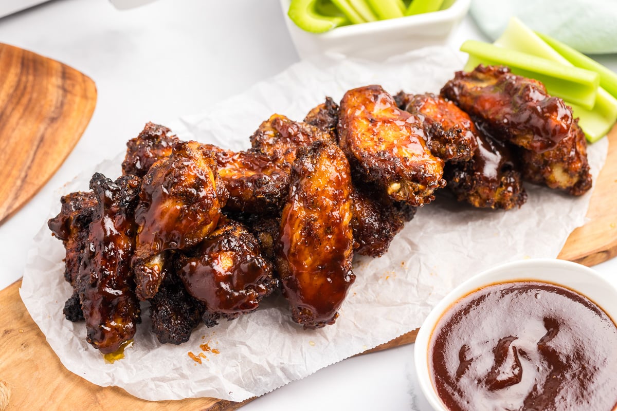 Saucy bbq chicken wings place on a piece of parchment paper.