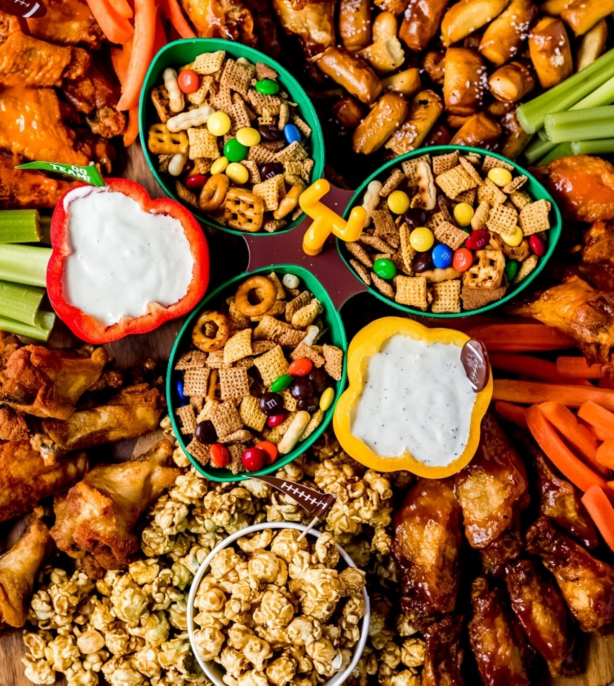 Buffalo wings, chex mix, veggies, and dip fill Wanderlust and Wellness game day board.