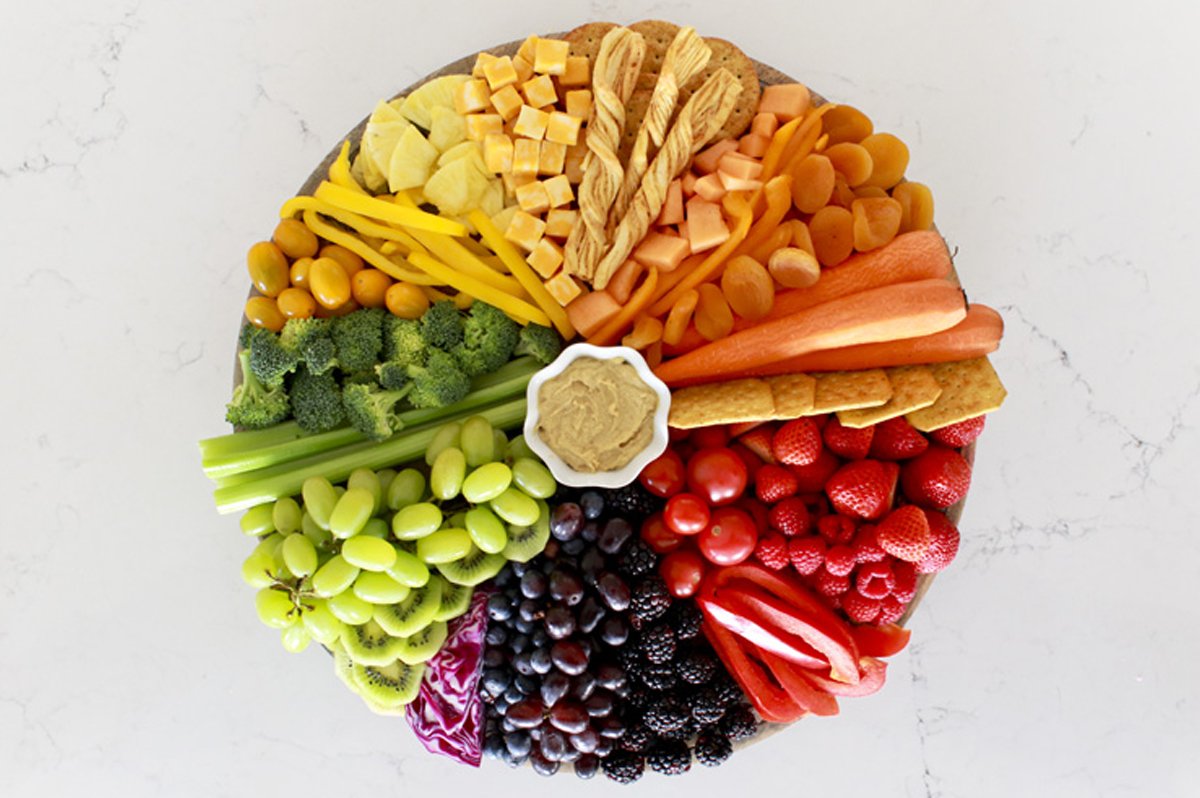 Jennifer maune's rainbow charcuterie board with veggies, cheese, fruit, and more.